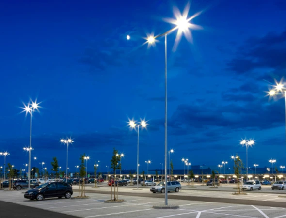 Pole lights illuminating a parking area, highlighting the safety and visibility benefits of proper pole light fixture setup.